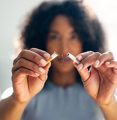 Closeup of woman breaking cigarette