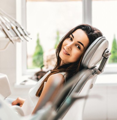 Woman sitting in dental chair and smiling