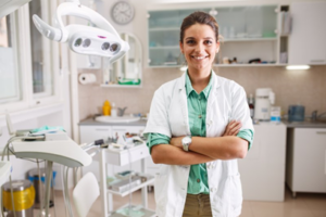 Dentist smiling in her office, equipment in the background