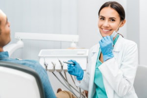 Cosmetic dentist smiling while treating patient